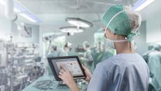 Surgeon in operating room looking at tablet
